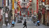 A man wearing a face mask crosses a quiet road in Melbourne's Chinatown area on August 13, 2020. Australia's virus-hit Victoria state reported a major drop in new coronavirus cases on August 13, but officials warned against complacency amid a 