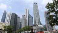 A man jogs along the Singapore River, as the financial business district is seen in the background, in Singapore on August 11, 2020. / AFP / Roslan RAHMAN
