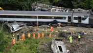 Members of the emergency services inspect the debris and derailed carriages at the scene of the train crash near Stonehaven in northeast Scotland on August 12, 2020. / AFP / POOL / Ben BIRCHALL