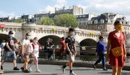 Pedestrians wearing protective face masks walk along the Seine river banks, as France reinforces mask-wearing as part of efforts to curb a resurgence of the coronavirus disease (COVID-19) across the country, Paris, France, August 15, 2020. REUTERS/Charles