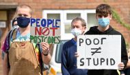 Students hold placards as they protest outside of the constituency office for Gavin Williamson, Conservative MP for South Staffordshire and Britain's current Education Secretary, in Codsall near Wolverhampton, central England on August 17, 2020 .AFP / Pau
