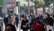 People wear face masks while walking along a pedestrian promenade in downtown Santiago, following the easing of lockdown restrictions amid the Covid-19 pandemic, on August 17, 2020. / AFP / Martin BERNETTI