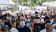 Pedestrians wear face masks as they walk in a congested street market of Lourges, southern France on August 18, 2020. / AFP / Christophe SIMON