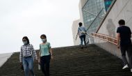 People wearing face masks walk down steps near a subway station, following the coronavirus disease (COVID-19) outbreak, in Beijing, China August 18, 2020. REUTERS/Tingshu Wang