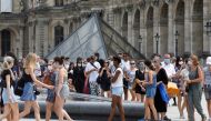 Visitors wearing protective face masks queue to enter the Louvre Pyramid in Paris, as France reinforces mask-wearing as part of efforts to curb a resurgence of the coronavirus disease (COVID-19) across the country, France, August 13, 2020. REUTERS/Charles