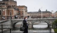 FILE PHOTO: A man wearing a protective mask walks past the Royal Swedish Opera, amid the coronavirus disease (COVID-19) outbreak in Stockholm, Sweden, April 27, 2020. Fredrik Sandberg/ REUTERS