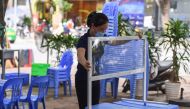 A worker sets up a plastic partition, used as a preventive measure against the spread of the COVID-19 novel coronavirus, at a bia hoi in Hanoi on August 20, 2020. / AFP / Nhac NGUYEN