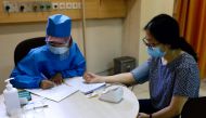 FILE PHOTO: FILE PHOTO: A healthcare worker checks the tension of a volunteer during a simulation for coronavirus vaccine clinical trials next week at the Faculty of Medicine at Padjadjaran University amid the COVID-19 pandemic in Bandung, Indonesia, Augu
