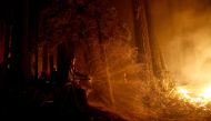 Cal Fire firefighter Anthony Quiroz douses water on a flame as he defends a home during the CZU Lightning Complex Fire in Boulder Creek, California, U.S. August 21, 2020. REUTERS/Stephen Lam