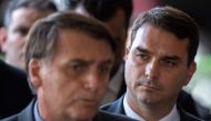 In this file photo taken on November 28, 2018, the president-elect of Brazil, Jair Bolsonaro (L) and his son Flavio Bolsonaro (R), arrive for a press conference on the appointment of the ministers of Citizenship, Tourism and Regional Development at the he