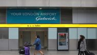 FILE PHOTO: Travellers pass a sign for Gatwick Airport in southern Britain, December 17, 2015. REUTERS/Neil Hall/File Photo/File Photo
