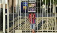 An FC Barcelona fan holds a placard calling for the resignation of club president Josep Maria Bartomeu and replacing him with Barcelona's Spanish defender Gerard Pique as fans gather outside the Camp Nou stadium in Barcelona on August 27, 2020 after Barce