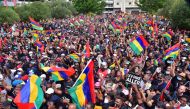 People wave the national flag as they attend a protest against the government's response to the oil spill disaster that happened in early August at St Louis Cathedral in Port Louis, on the island of Mauritius, on August 29, 2020. Beekash Roopun / L'Expres
