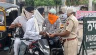 A police personnel (R) checks travel passes from commuters after lockdown norms for weekends and public holidays in the state have been imposed as a preventive measure against the Covid-19 coronavirus, in Amritsar on August 29, 2020. (AFP / NARINDER NANU)