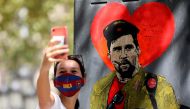 A woman takes a selfie with a mural of Lionel Messi dressed as Che Guevara as FC Barcelona's squad arrive for coronavirus disease (COVID-19) test, ahead of the resumption of training on August 31, in Barcelona, Spain August 30, 2020. REUTERS/Nacho Doce
