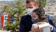 French President Emmanuel Macron hugs a blast victim while attending a ceremony to mark Lebanon's centenary in Jaj Cedars Reserve Forest, northeast of the capital Beirut, on September 1, 2020. / AFP / POOL / GONZALO FUENTES
