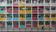 A man wearing a face mask as a precautionary measure against COVID-19 coronavirus waks past walks past a housing building in Hong Kong on August 29, 2020.  / AFP / May James / May JAMES