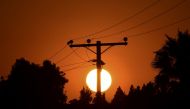 The sun sets behind power lines in Los Angeles, California on September 3, 2020, ahead of a heatwave to arrive September 4 through the Labour Day weekend prompting a statewide flex alert. / AFP / Frederic J. BROWN