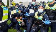 Police tackle protesters in Melbourne on September 5, 2020 during an anti-lockdown rally protesting the state's strict lockdown laws as a preventive measure against the COVID-19 coronavirus. / AFP / William West 