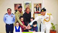 Ambassador of Islamic Republic of Pakistan to the State of Qatar, H E Syed Ahsan Raza Shah, cutting a cake along with Pakistan Armed Forces officers and children to mark Pakistan Defence Day at the Pakistan Embassy in Doha, yesterday. PICS: ABDUL BASIT / 