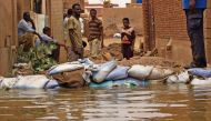 Sudanese stand amidst flood waters in Tuti island, where the Blue and White Nile merge in the Sudanese capital Khartoum, on September 3, 2020. / AFP / ASHRAF SHAZLY
