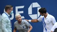 Novak Djokovic of Serbia and a tournament official tend to a linesperson who was struck with a ball by Djokovic against Pablo Carreno Busta of Spain (not pictured) on day seven of the 2020 U.S. Open tennis tournament at USTA Billie Jean King National Tenn