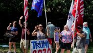 FILE PHOTO: Trump supporters wave flags as the motorcade carrying U.S. President Donald Trump departs from the Trump National Golf Club in Sterling, Virginia, U.S., September 6, 2020. REUTERS/Joshua Roberts/File Photo
