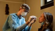 A healthcare worker takes a nasal swab sample inside a chapel dedicated to Saint Roch, patron saint of the sick, that has been transformed into a coronavirus disease (COVID-19) testing centre in Antwerp, Belgium September 4, 2020. Picture taken September 