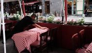 (FILES) In this file photo taken on August 30, 2020 a member of the staff prepares a table at a restaurant in Manhattan in New York City. / AFP /  SPENCER PLATT