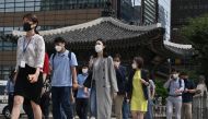 People wearing face masks cross a road in Seoul on September 11, 2020. South Korea largely overcame an early COVID-19 coronavirus outbreak with extensive tracing and testing, but is now battling several outbreaks. / AFP / Jung Yeon-je
