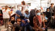 Migrants wait to receive treatment at the Doctors Without Borders (MSF) clinic near a new makeshift camp on the island of Lesbos on September 15, 2020.  AFP / ANGELOS TZORTZINIS
