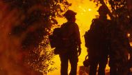 ARCADIA, CA - SEPTEMBER 13: Mill Creek Hotshots set a backfire to protect homes during the Bobcat Fire on September 13, 2020 in Arcadia, California.  David McNew/Getty Images/AFP
