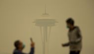People take photos against the backdrop of the Space Needle as smoke from wildfires fills the air at Kerry Park on September 12, 2020 in Seattle, Washington. Lindsey Wasson/Getty Images/AFP