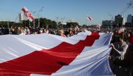Opposition supporters carry a historical white-red-white flag of Belarus as they take part in a rally to demand the resignation of Belarusian President Alexander Lukashenko more than a month after the disputed presidential election, in Minsk, Belarus Sept