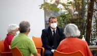 French President Emmanuel Macron (C) meets with elderly people in 'La Bonne Eure' nursing home (EPHAD) in Bracieux, Loir-et-Cher, on September 22, 2020, as part of a visit to welcome the mobilisation of nursing home staff and to call for the preservation 
