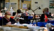 FILE PHOTO: Workers wearing masks and separated by plexiglass inspect ballots at the Thurston County Ballot Processing Center in Tumwater, Washington, U.S. July 23, 2020. REUTERS/Lindsey Wasson