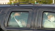 US President Trump waves from the back of a car in a motorcade outside of Walter Reed Medical Center in Bethesda, Maryland on Ocotber 4, 2020. / AFP / ALEX EDELMAN
