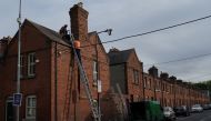 Workers make repairs to the roof of a residential terraced house, amid the coronavirus disease (COVID-19) outbreak, in Dublin, Ireland October 1, 2020. (REUTERS/Clodagh Kilcoyne)