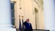 US President Donald Trump salutes as he poses without a face mask on the Truman Balcony of the White House after returning from being hospitalized at Walter Reed Medical Center for coronavirus disease (COVID-19) treatment, in Washington, US October 5, 202