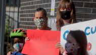 Parents and children hold signs during a protest against the closing of Public School 130 outside the school building for safety reasons, following the outbreak of the coronavirus disease (COVID-19) in the Brooklyn borough of New York City, U.S., October 