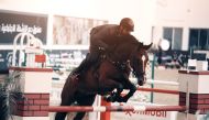 Mohammed Saeed Haidan guiding his horse over an obstacle on his way to win the Medium Tour competition at the QEF indoor Arena yesterday.