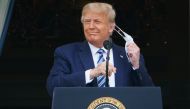 US President Donald Trump takes his mask off before speaking from the South Portico of the White House in Washington, DC during a rally.  AFP / MANDEL NGAN