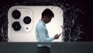 FILE PHOTO: A man walks next to an advertisement for Apple's new iPhone 11 Pro at the Apple Store in IFC, Central district, Hong Kong, China October 10, 2019. REUTERS/Athit Perawongmetha