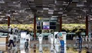 People wearing protective face masks walk past self check-in machines, amid the spread of the coronavirus disease (COVID-19) at the Changi Airport in Singapore October 12, 2020. REUTERS/Edgar Su