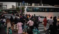 People try to pass through traffic as they commute with shared bicycles during rush hour in Beijing on October 14, 2020. / AFP / NICOLAS ASFOURI