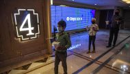 People invited as 'Covid-19 warriors' and their families to a special screening of Bollywood movie 'Tanhaji' queue to enter a cinema auditorium in New Delhi on October 15, 2020, with some states still keeping theatres closed amid the Covid-19 coronavirus 