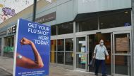 (FILES) In this file photo taken on August 19, 2020 a man walks past a free flu shot advertisement outside of a drugstore in New York. AFP / Bryan R. Smith