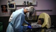 A nurse tends to an elderly woman suspected of being infected with Covid-19 at the emergency service of the Andre Gregoire hospital in Montreuil east of Paris on October 15, 2020. / AFP / Christophe ARCHAMBAULT