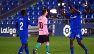Getafe's Togolese defender Djene Dakonam (L) and Getafe's Cameroonian defender Allan Nyom (R) celebrate their victory as Barcelona's Argentine forward Lionel Messi walks past at the end of the Spanish League football match between Getafe and Barcelona at 