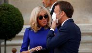 In this file photo taken on July 13, 2020, French President Emmanuel Macron wearing a face mask speaks with his wife Brigitte Macron after giving a speech to France's armed forces at the Hotel de Brienne, the French Ministry of Armed Forces, in Paris. Bri